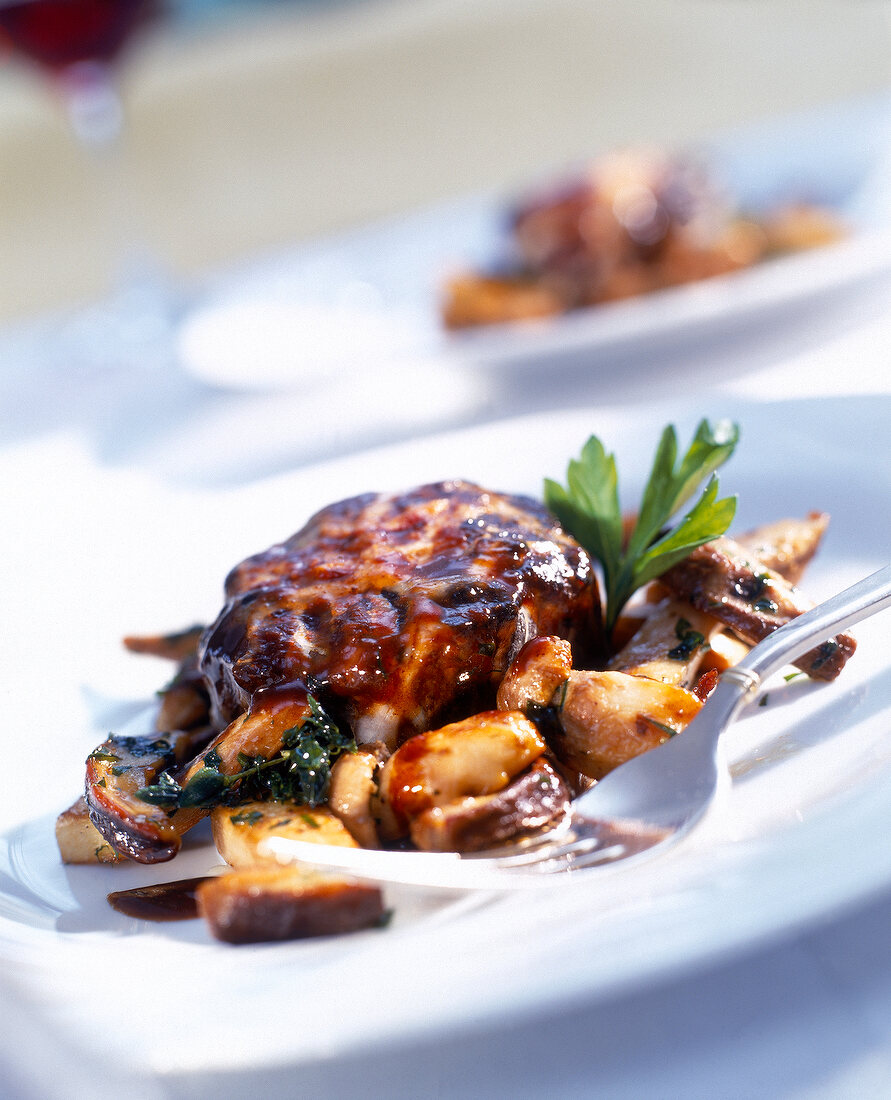 Filled oxtail and fried porcini mushrooms on plate