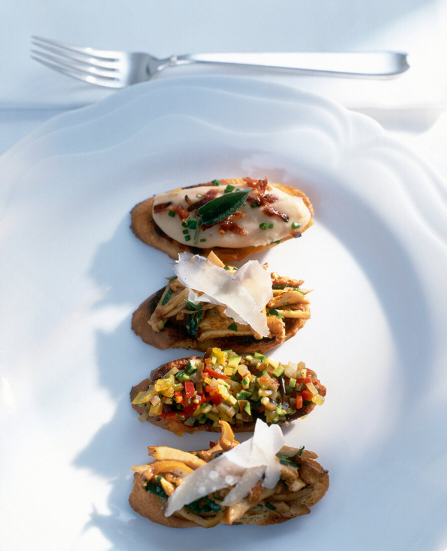 Crostinis with chanterelle mushrooms, bean puree and ratatouille on plate