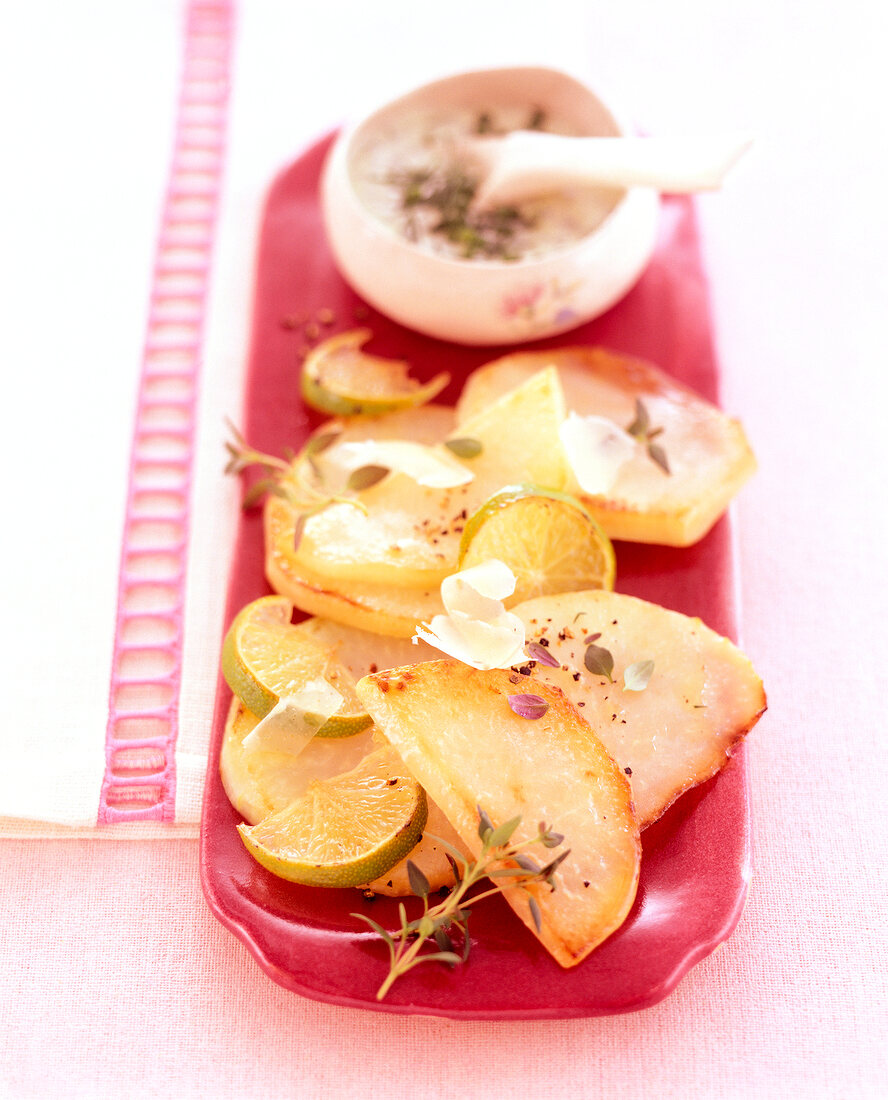 Close-up of roasted kohlrabi with sauce in a bowl on tray