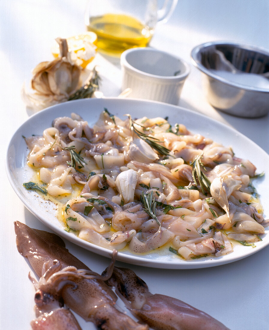 Calamaretti marinated with herbs and tossed in butter on plate