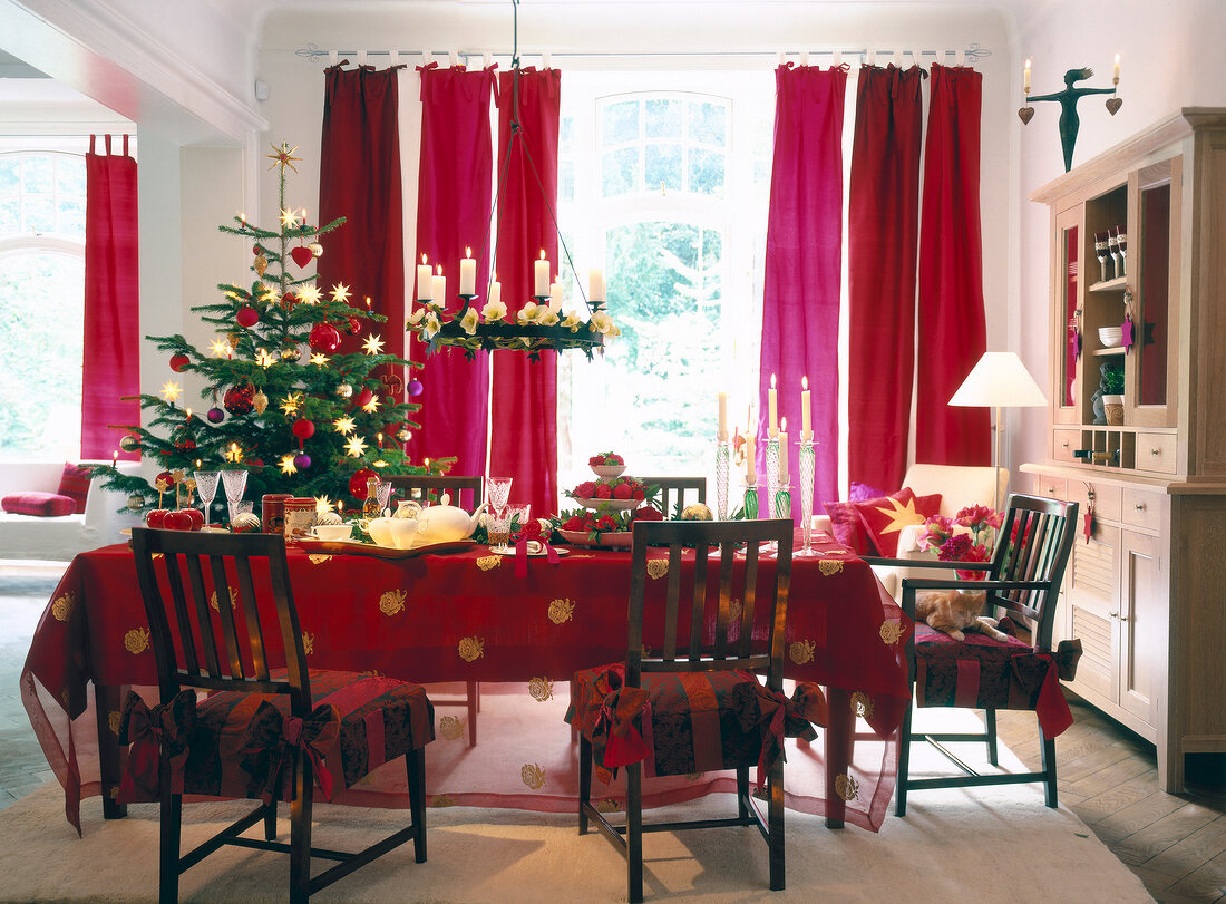 weihnachtlich gedeckter Tisch, Weih- nachtsbaum, rote Vorhänge