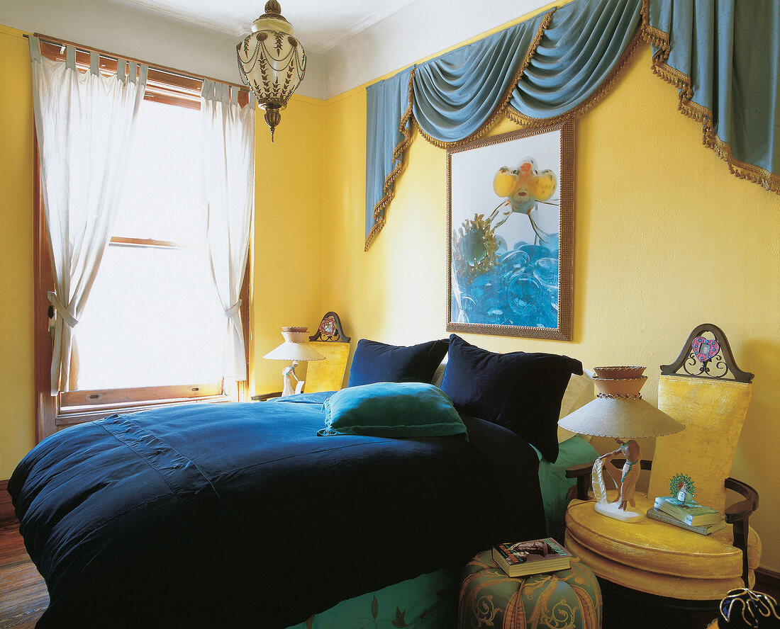 Bedroom with yellow-blue velvet covered bed and ceiling