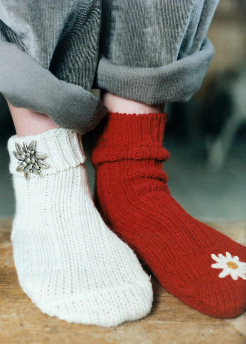 Close-up of human feet wearing red and white edelweiss socks