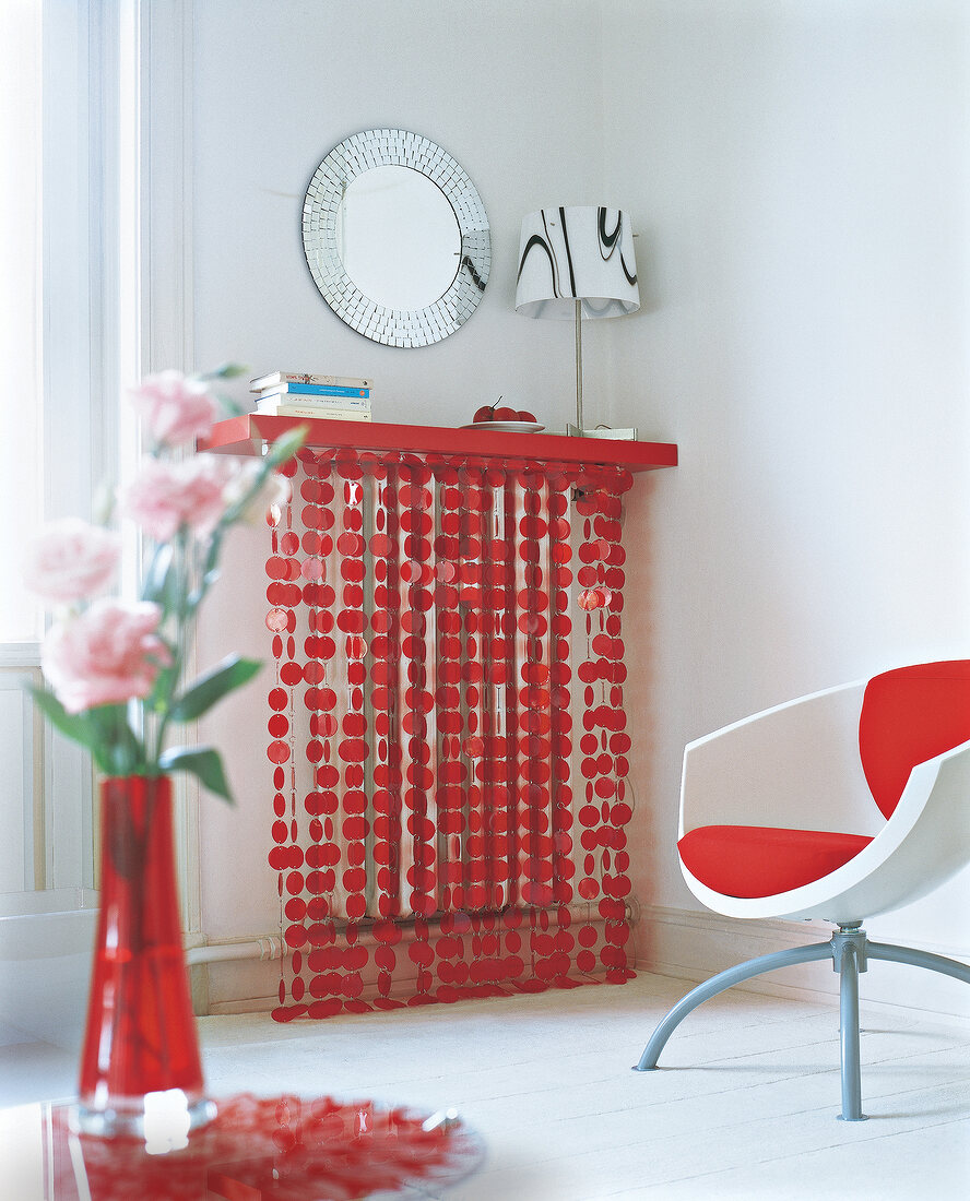 Room with chair, red cushion, radiator cover and flower vase