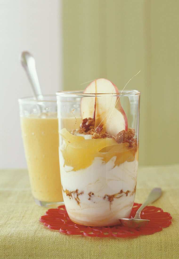 Mango lassi with apple in two glasses with spoons