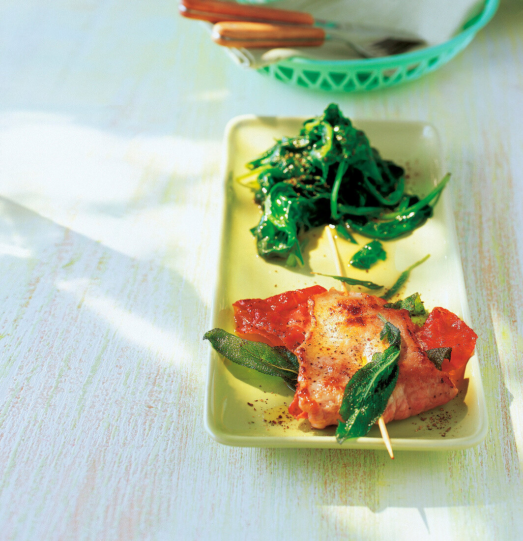 Veal escalope with parma ham and spinach on plate