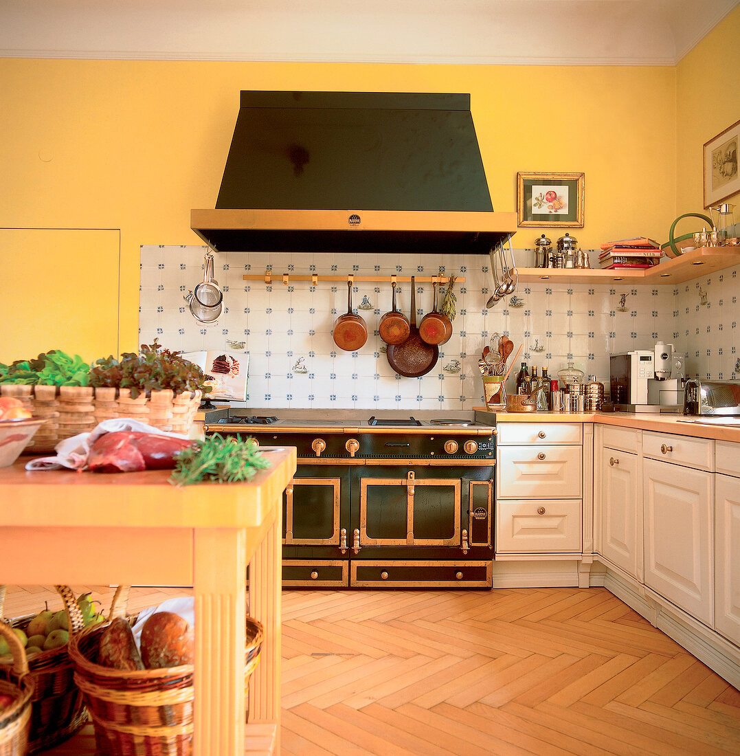 Black hood and cast-iron stove with two oven and cabinets in kitchen