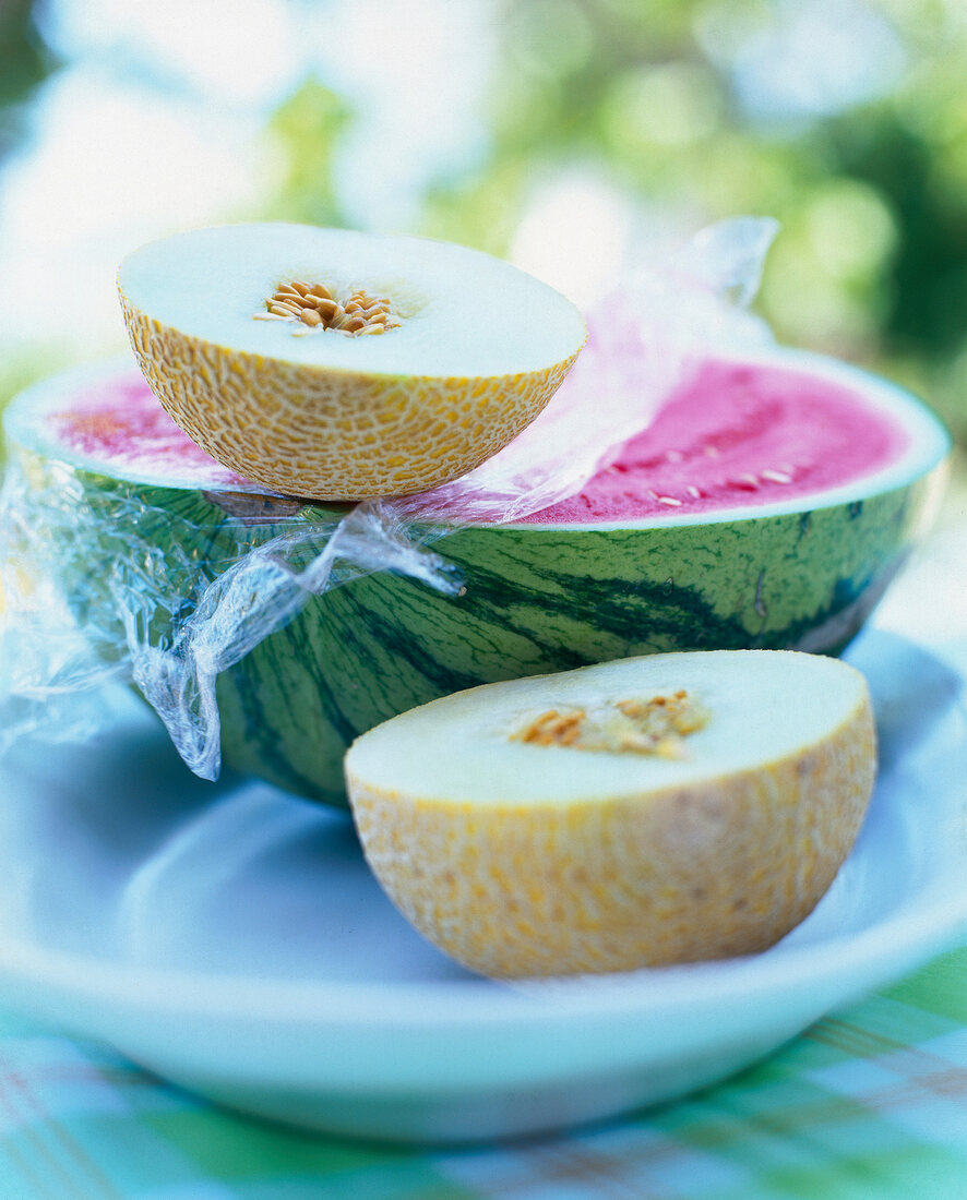 Close-up of half water melon with two halved muskmelon on plate