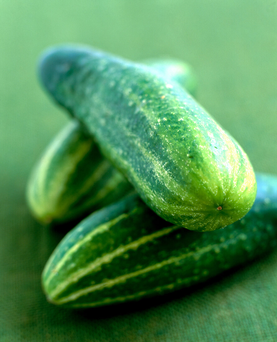 Close-up of fresh cucumbers on green surface