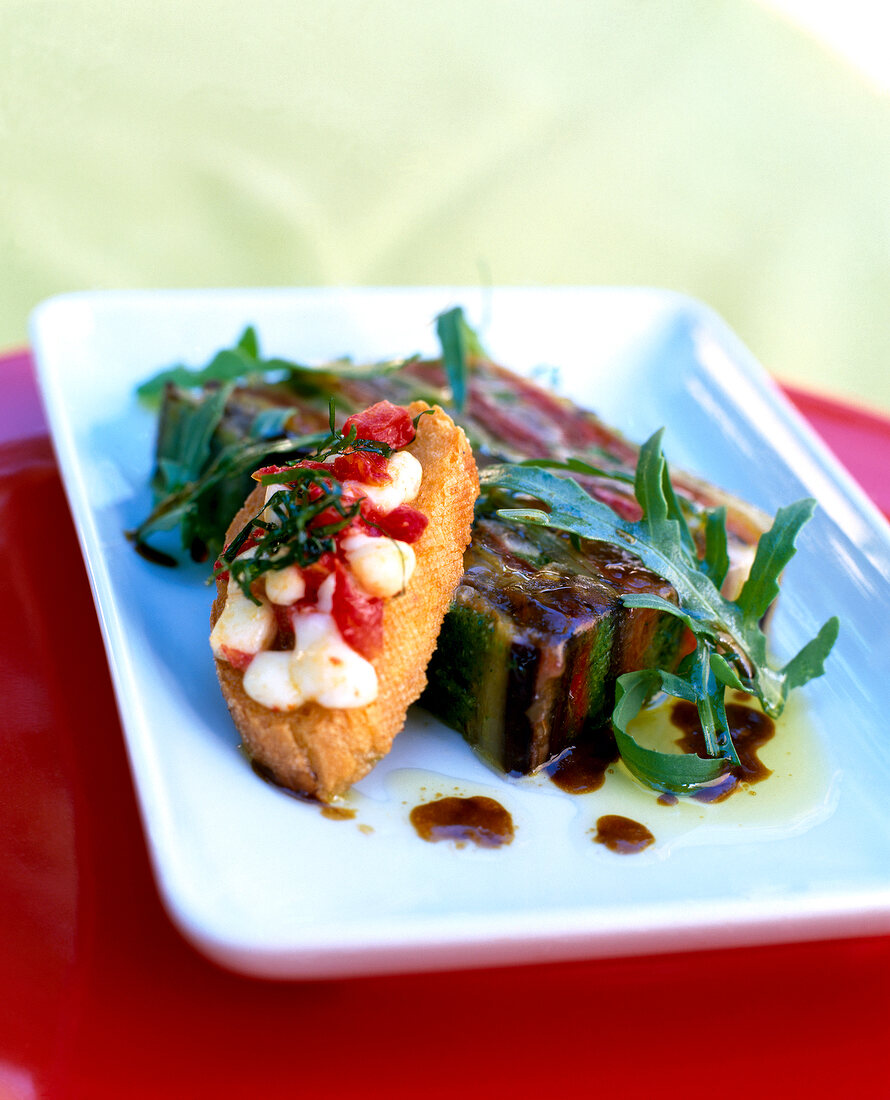 Mediterranean vegetable jelly with sardines on rectangular plate