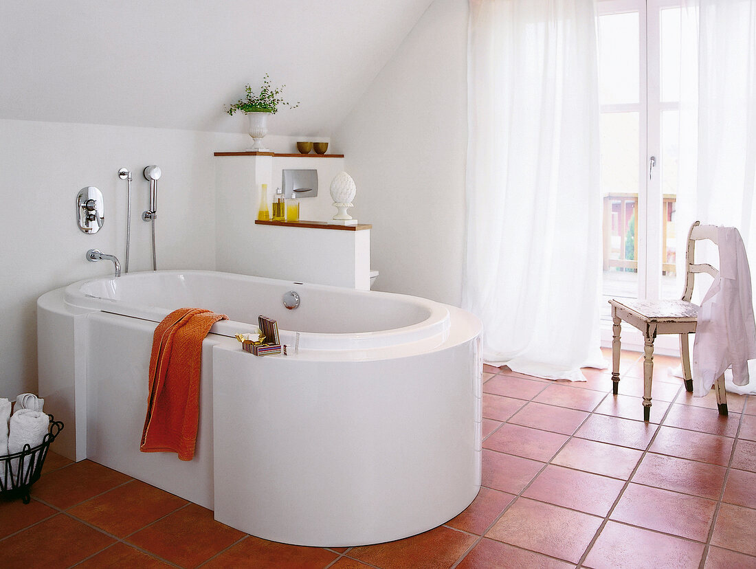 Bad mit frei stehender Badewanne mit breitem Rand auf Steingutfliesen