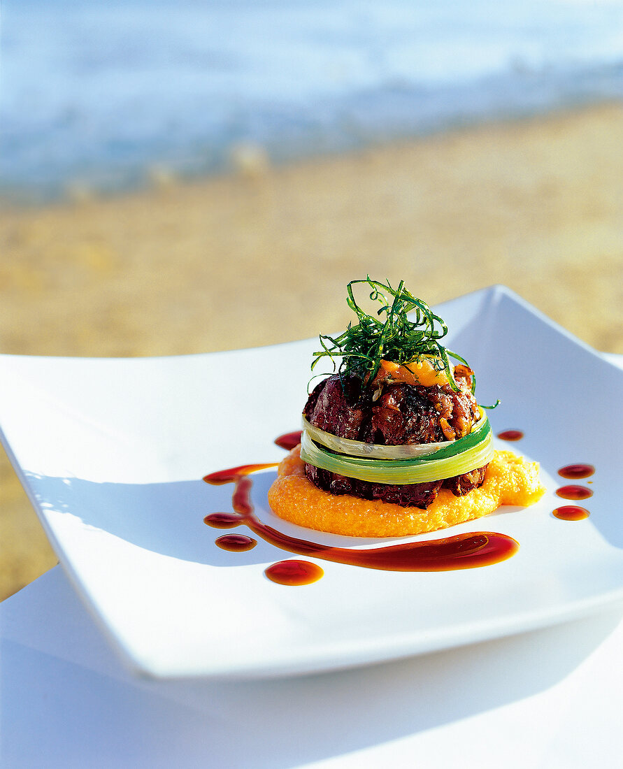 Oxtail with polenta and tomato cream on plate