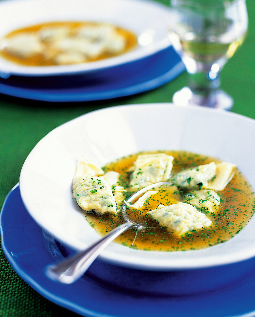 Close-up of spinach filling trout soup with ravioli kept in bowl