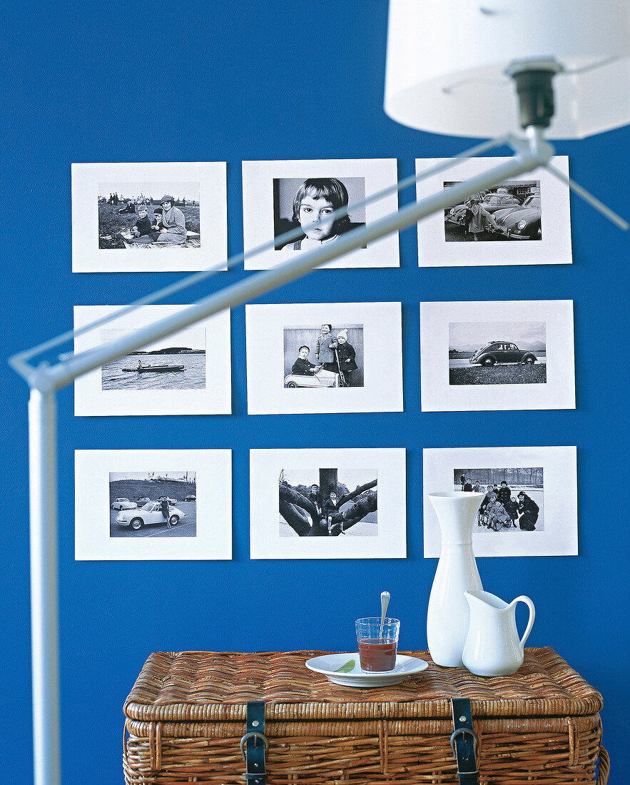 Nine black and white photos with a white border on blue wall