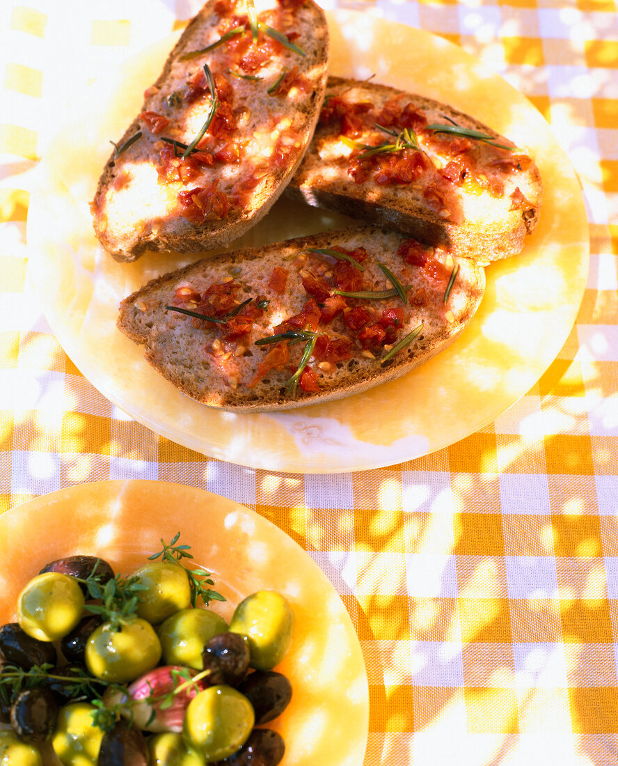 Close-up of tapas dishes with bread, tomato and olive