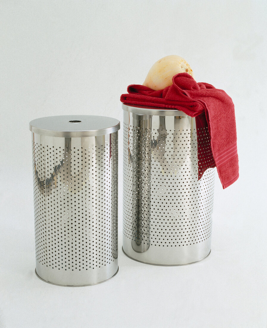 Two stainless steel laundry baskets with red towel on white background