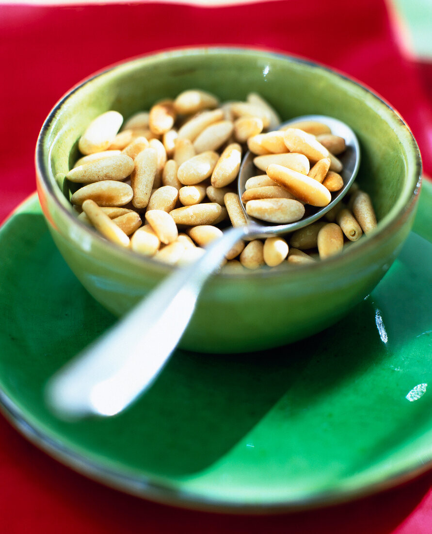 Pine nuts with silver spoon in bowl