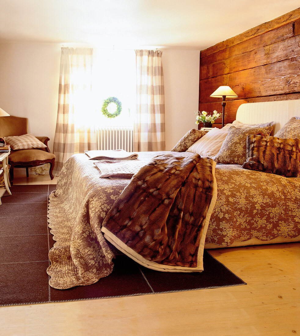 View of bedroom with brown floral bed sheet, blankets and pillows