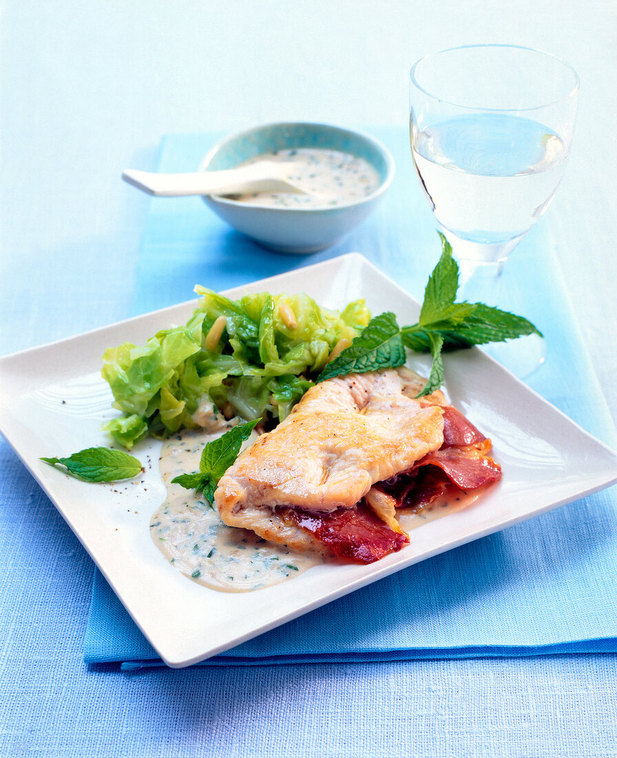 Turkey breast with mint sauce and kale leaves on plate