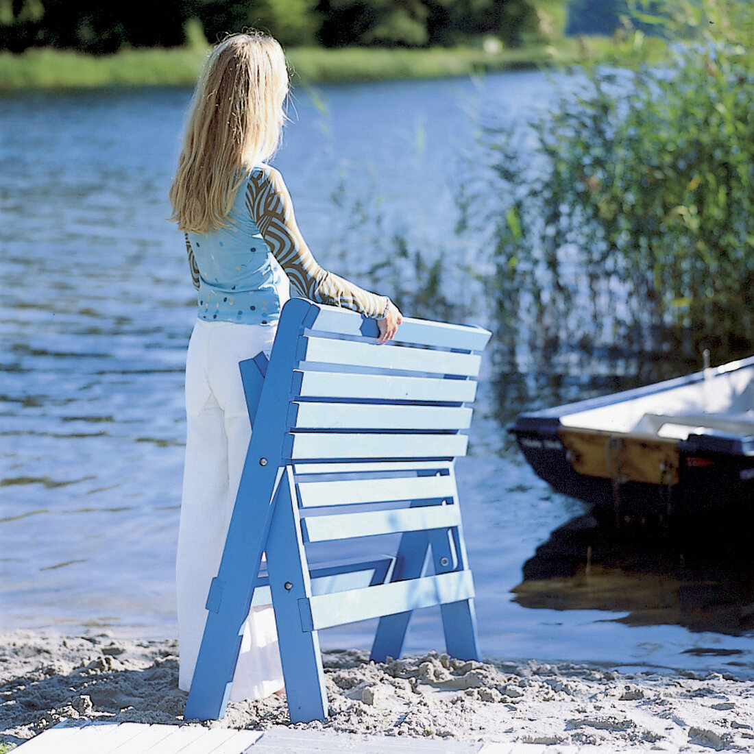Mädchen, Kind, langes blondes Haar, am See mit Klappliege in blau