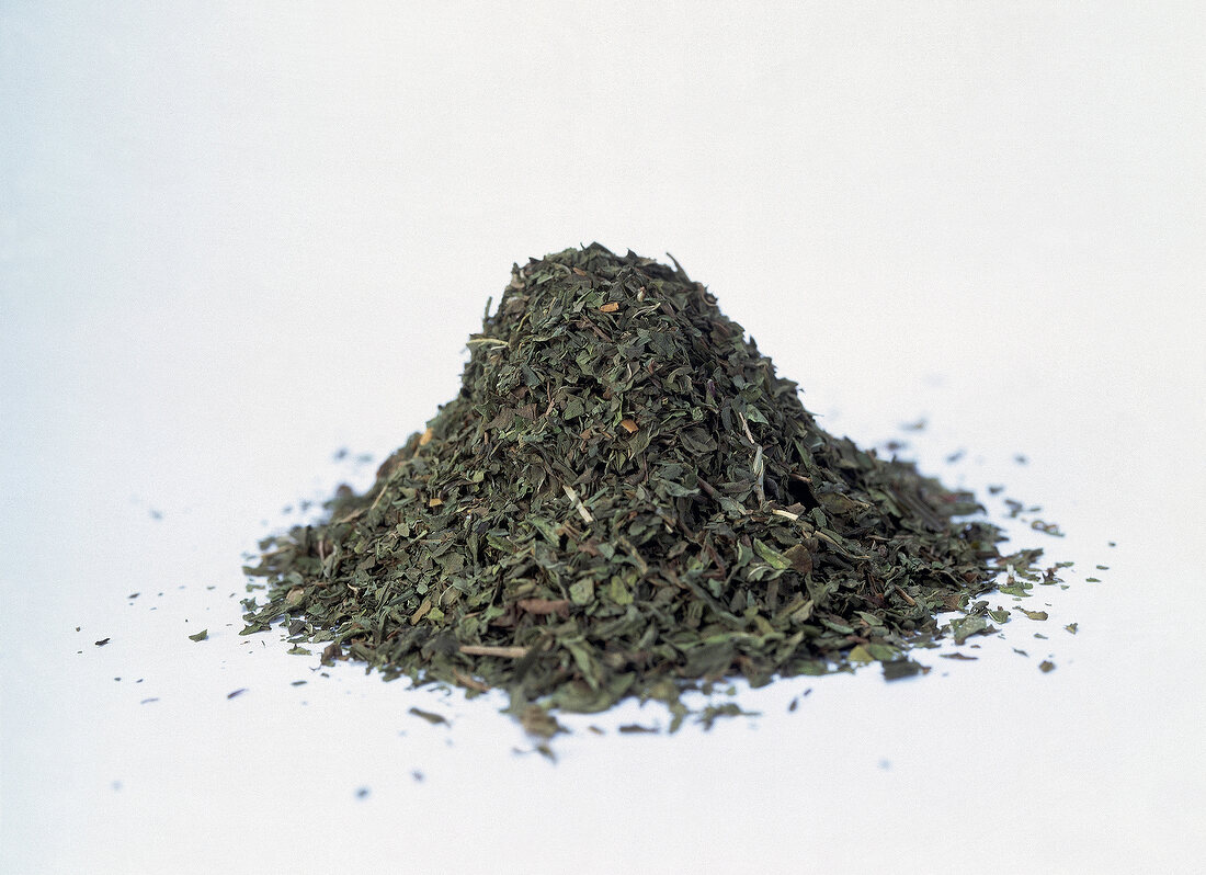 Pile of green tea leaves on white background