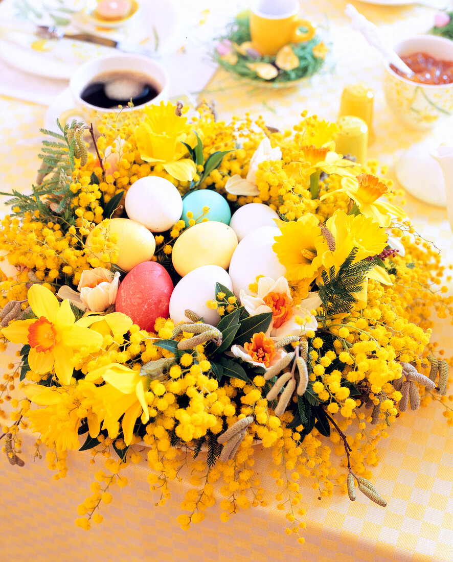 Close-up of Easter basket with yellow flowers and colourful Easter eggs