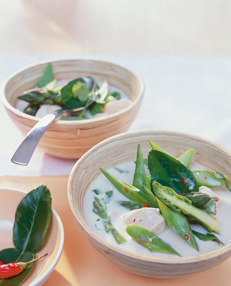 Close-up of asparagus and coconut soup with chicken in bowl