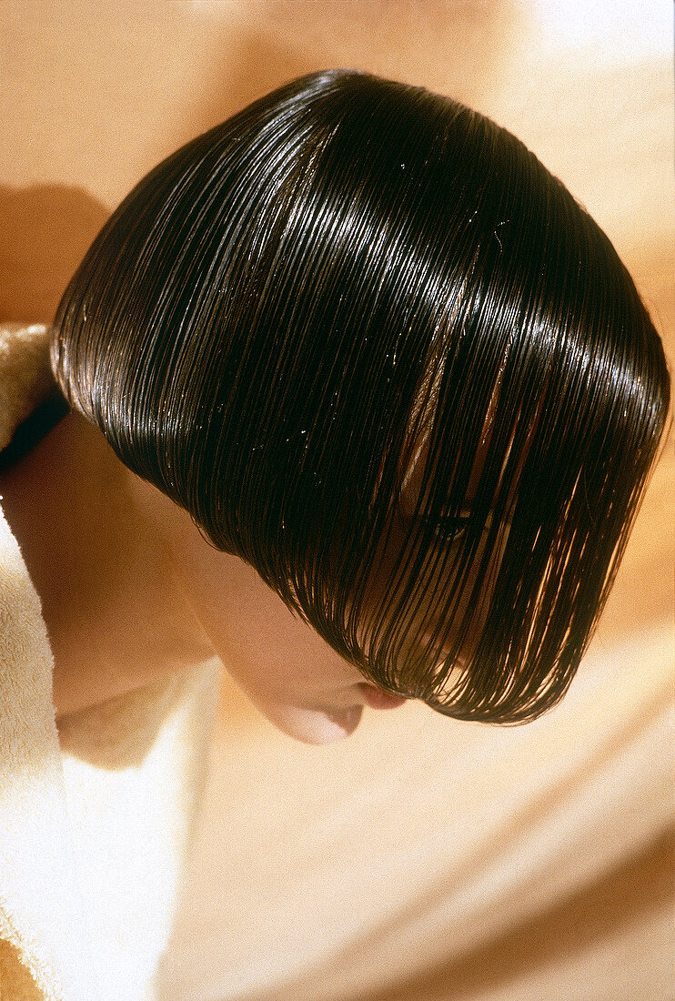 Close-up of pretty woman with oiled hair, looking away