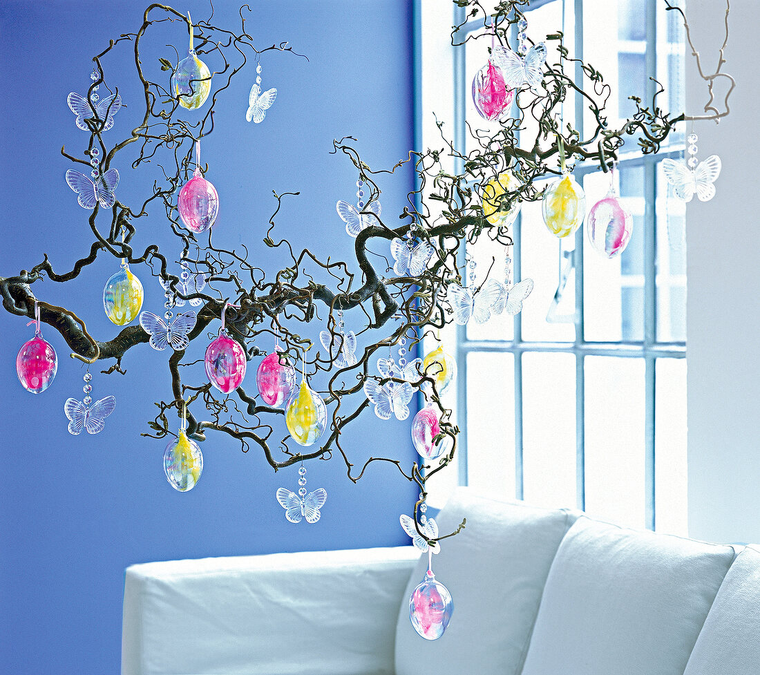 Willow branch decorated with glass eggs and glass butterflies