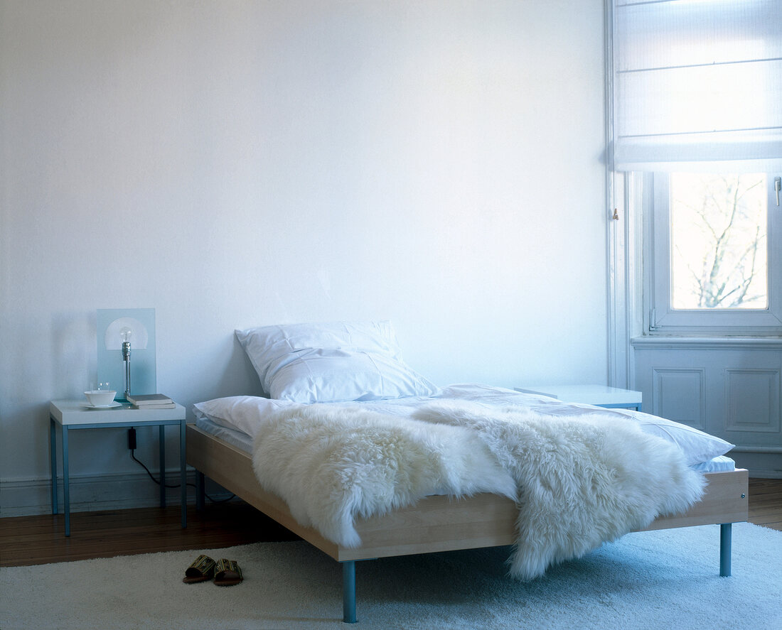 Bedroom with fur carpet, bed and fur blanket