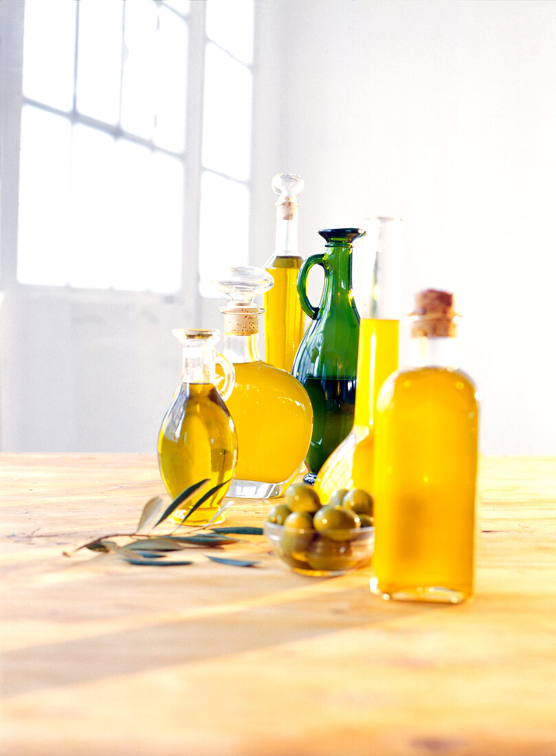 Speiseöl, Olivenöl, Oliven, Still, in Krügen auf Holztisch