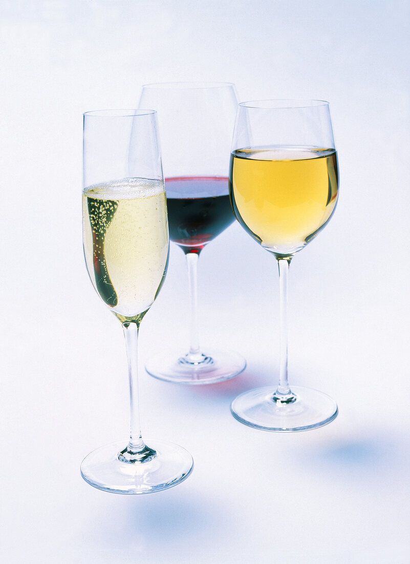 Champagne, white wine and red wine in three different glasses