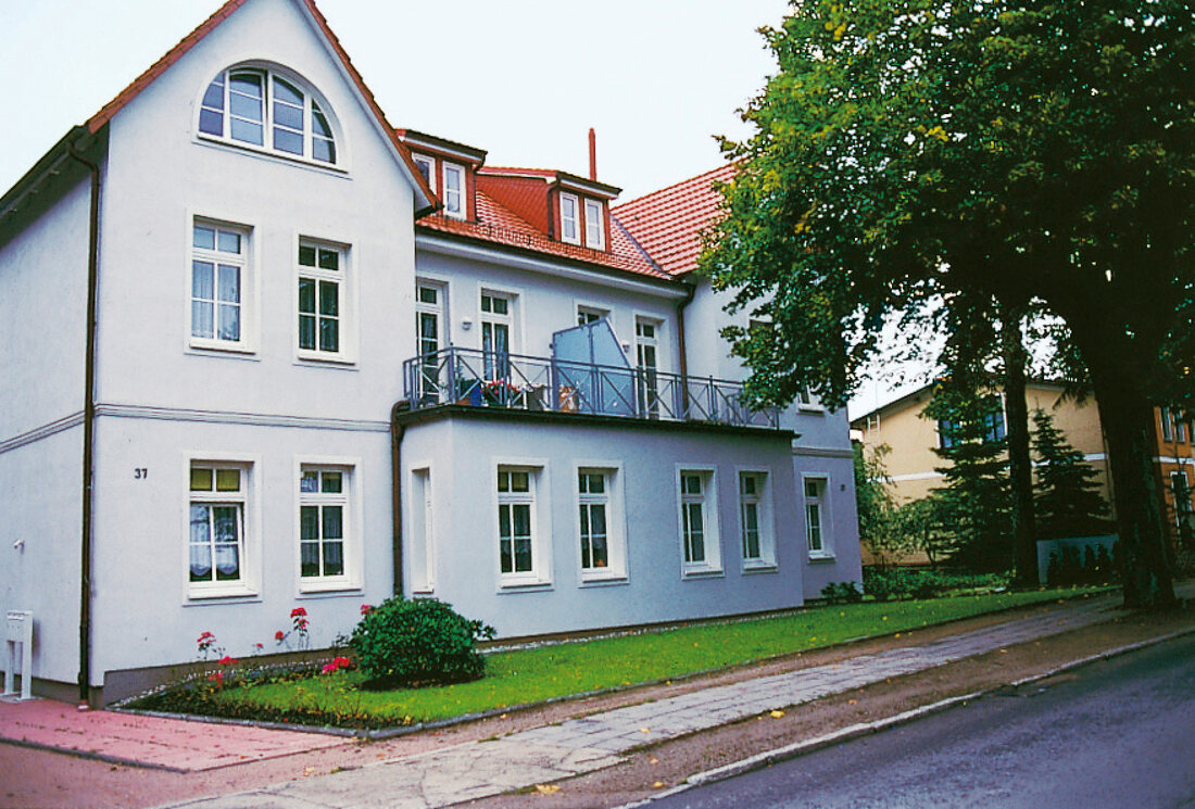 weiße Villa mit rotem Ziegeldach. 