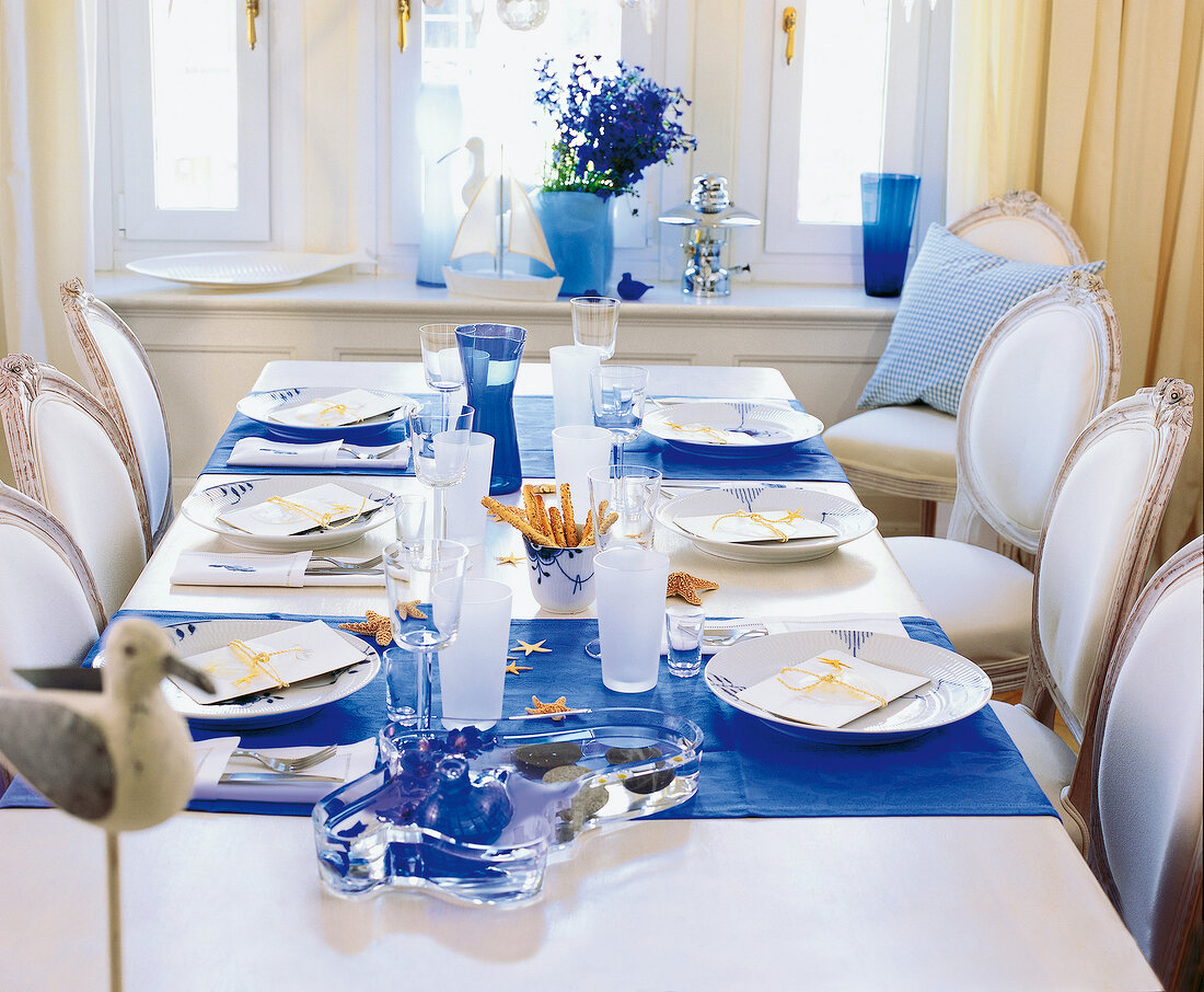 Dining table decorated with blue and white cutlery