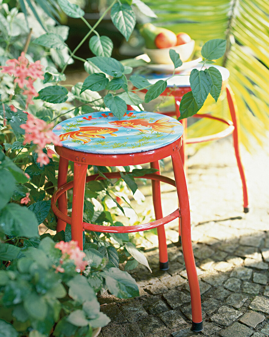 Metal stool with fish printed on it in garden