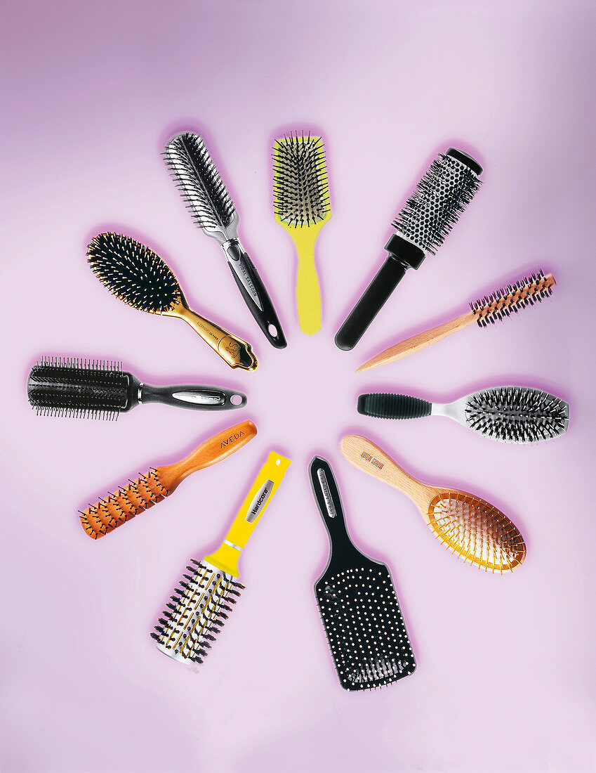 Different type of hair brushes on pink background