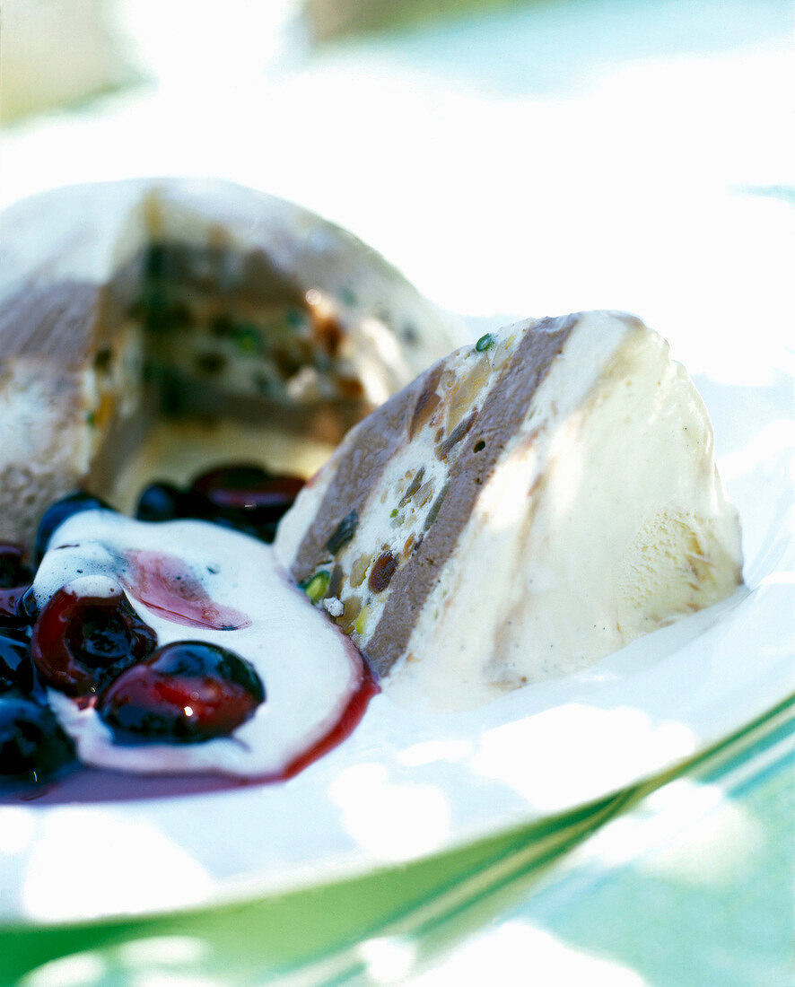 Close-up of cassata with cherry sauce and zabaglione on plate