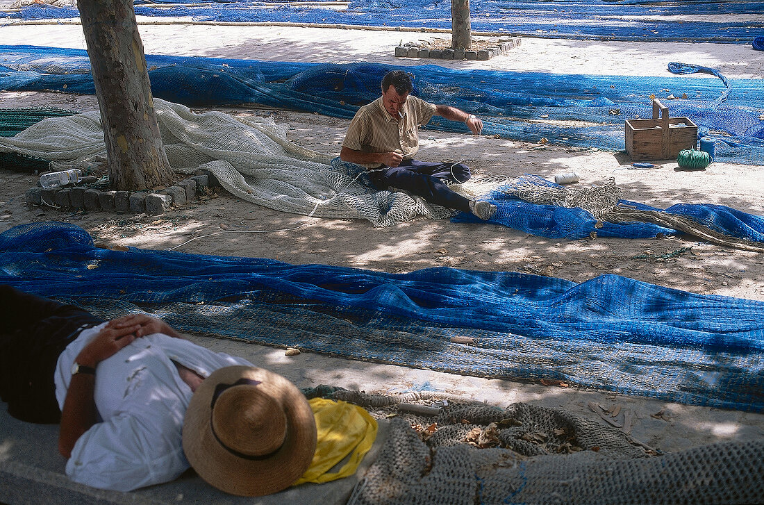 Fisherman mending nets on port of Palma, Mallorca, Spain