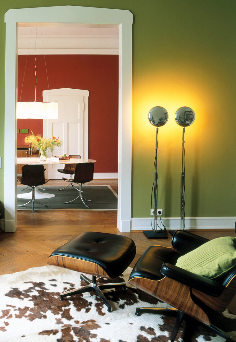 Living room with green walls, lounge chair and cowhide rug