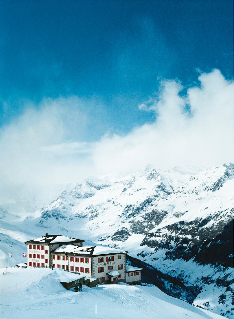 View of hotel in snow capped mountains, Valais, Switzerland