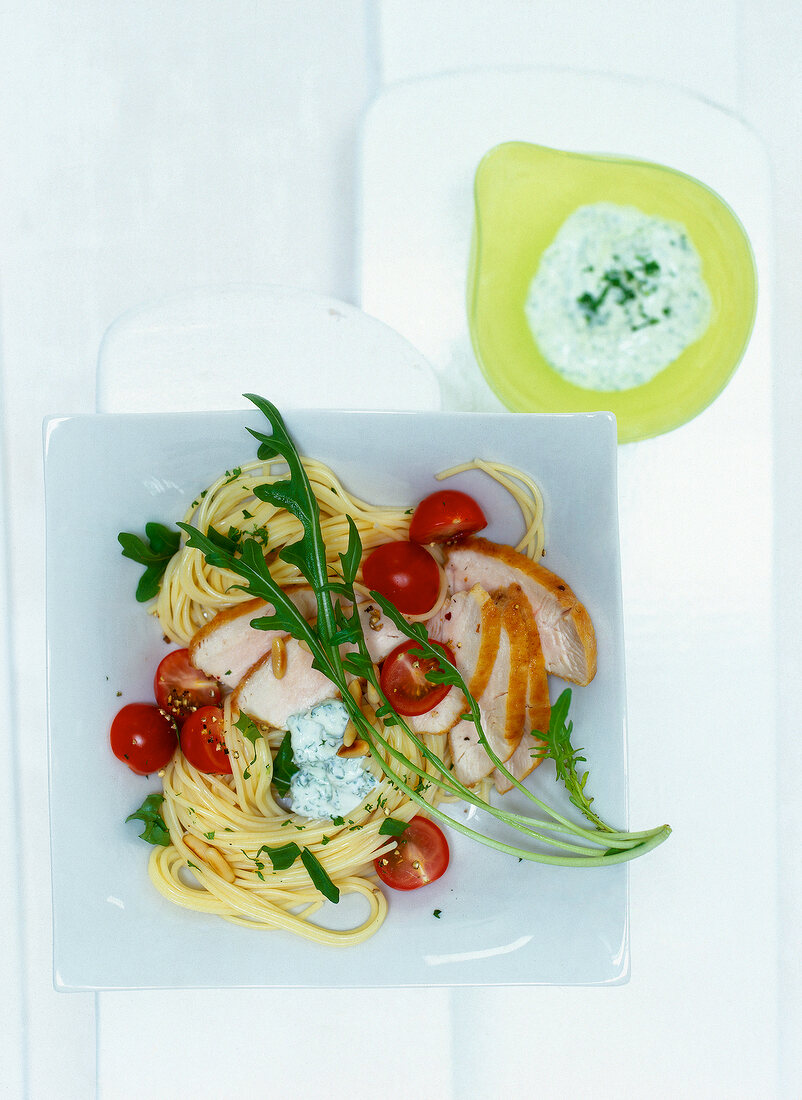 Nudelsalat mit Gefügelstreifen Strauchtomaten, Rauke, Pinienkerne