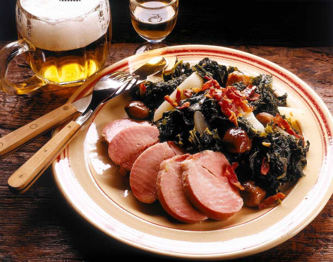 Green cabbage with pears, chestnuts and pork on plate