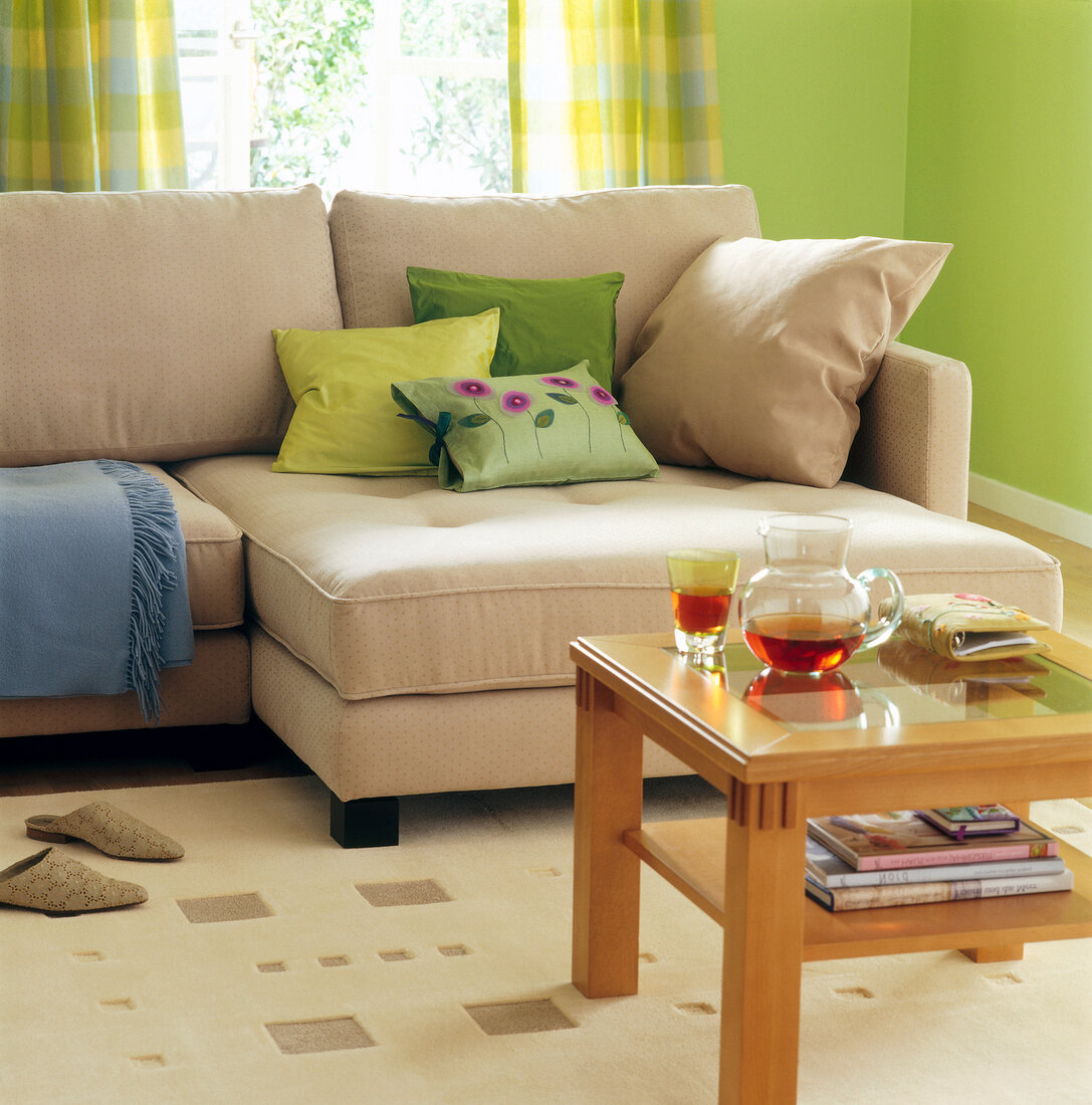 Living room with sofa, pillows in beige and green colour