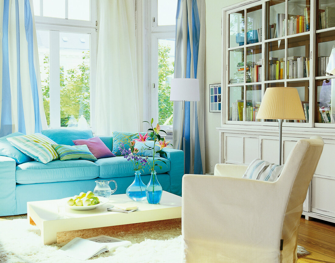 Living room with blue sofa, chairs and side table with book shelves