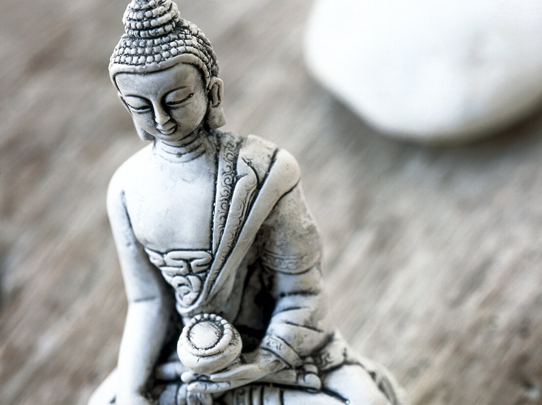 Close-up of small Buddha statue made of stone
