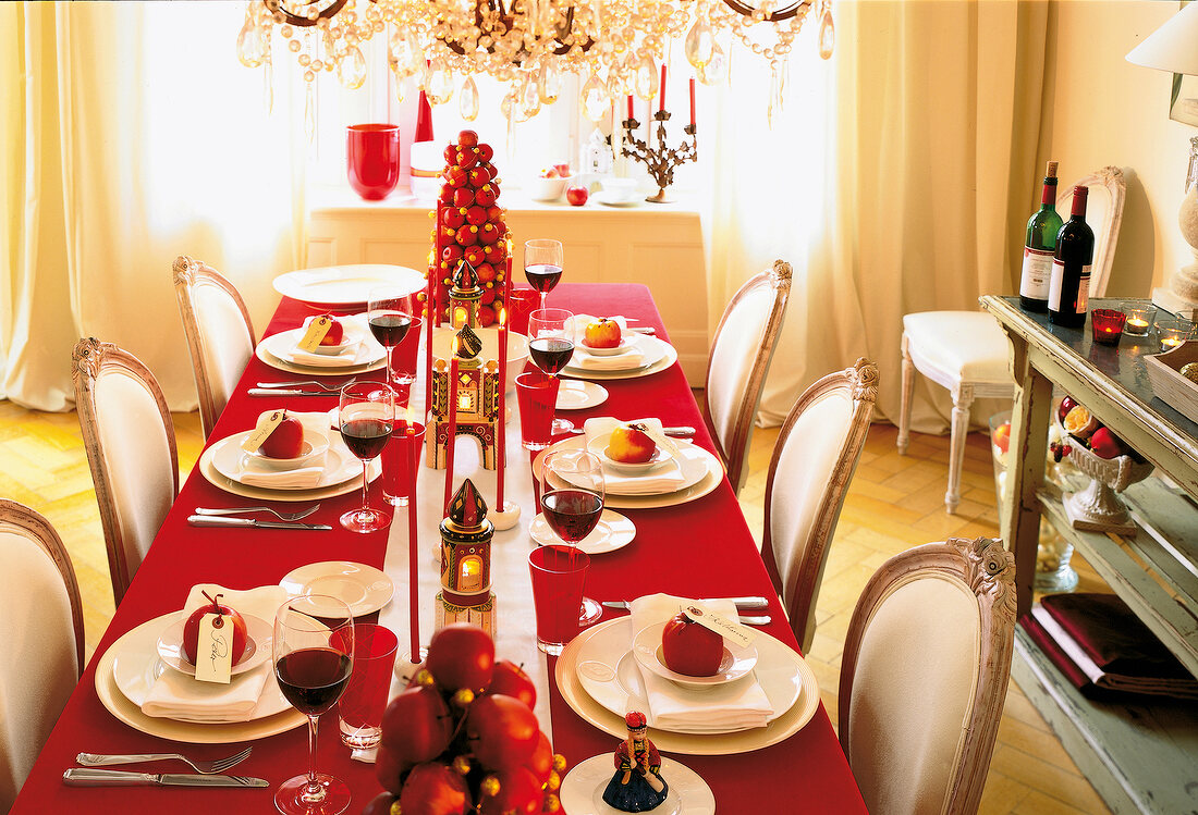 Christmas table decorated with red velvet tablecloth, wine and apples