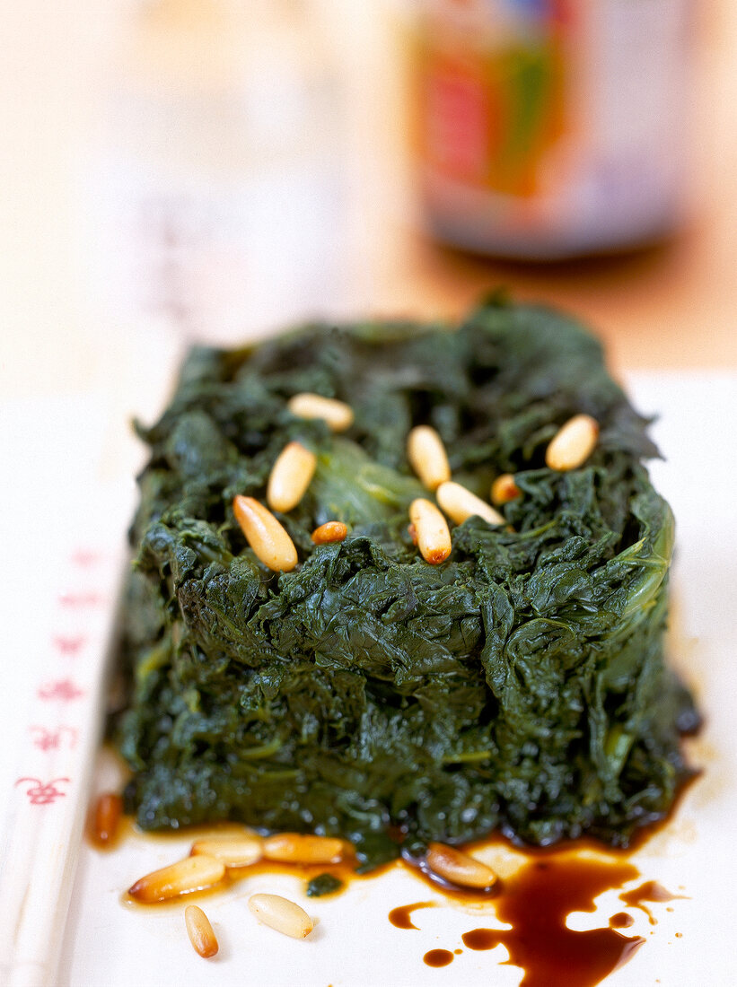 Spinach with pine nuts dressing on tray