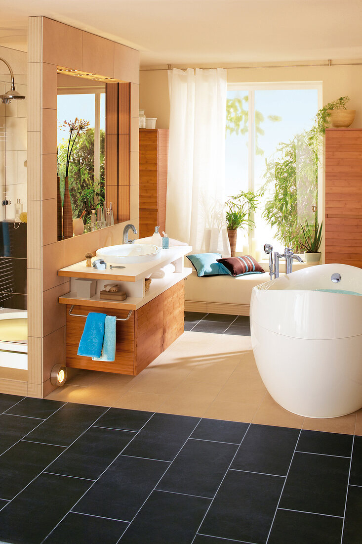 Interiors of wooden bathroom with bathtub and shower stall