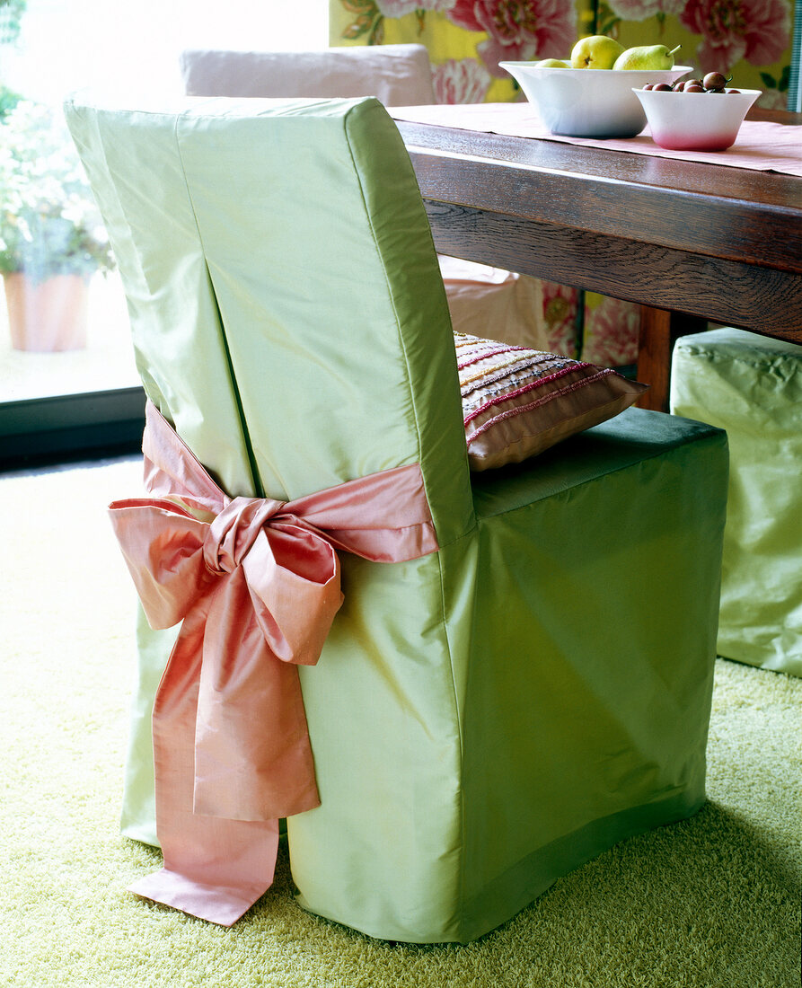 Chair covered with green silk fabric slipcover and cushion on chair