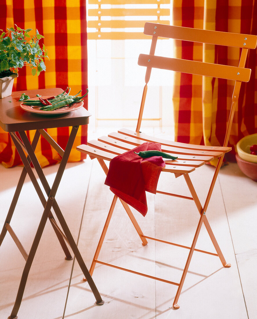 Close-up of folding chair with side table